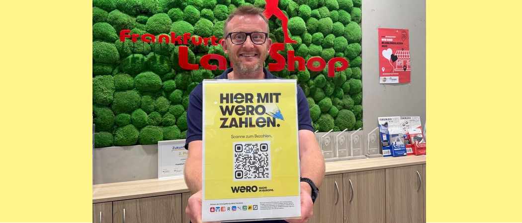 Jost Wiebelhaus vom Frankfurter Laufshop hält einen Wero-QR-Code hoch